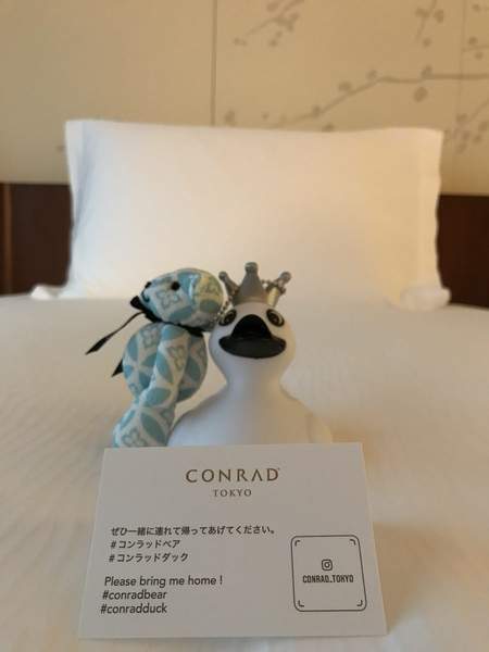 コンラッドベアのぬいぐるみがベッドに置かれている写真