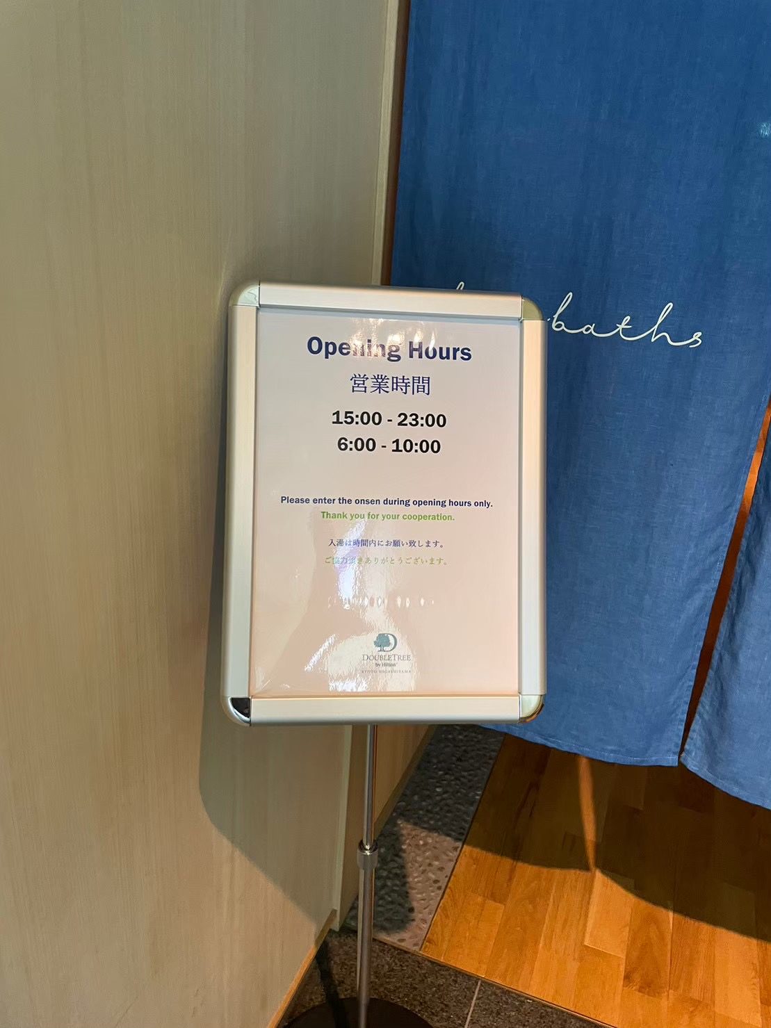 ダブルツリーbyヒルトン京都東山 大浴場入口の営業時間案内 15時から23時と6時から10時