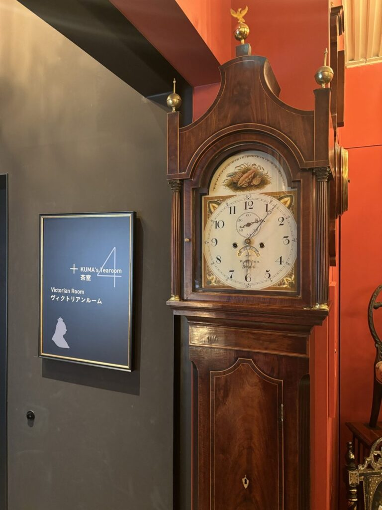 BAM鎌倉4階のフロアサイン。KUMA' Tearoom 茶室とVictorian Room ヴィクトリアンルームの表示、ヴィクトリア女王のシルエット。隣に英国製の柱時計