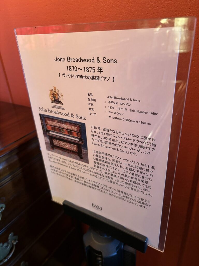 BAM鎌倉のジョン・ブロードウッド＆サンズ製ピアノ（1870〜1875年）の解説パネル。王室御用達のメーカーであることや材質のローズウッド、寸法まで記載されている