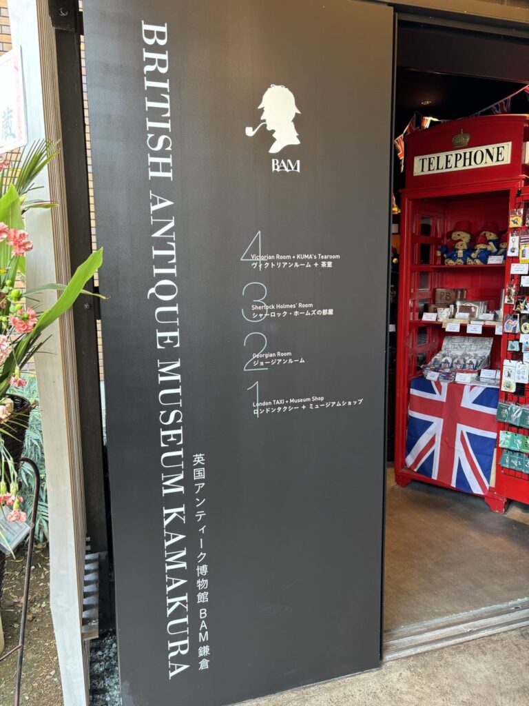 BAM鎌倉の入口サイン。1階ロンドンタクシーとミュージアムショップ、2階ジョージアンルーム、3階シャーロック・ホームズの部屋、4階ヴィクトリアンルームと茶室というフロア構成が書かれている
