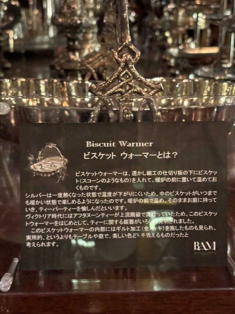 BAM鎌倉の展示に添えられた日本語の解説プレート。ビスケットウォーマーが銀で作られた理由が書かれている