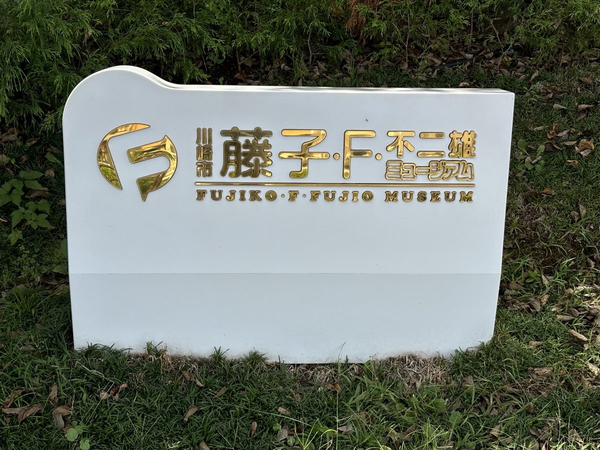 川崎市 藤子・F・不二雄ミュージアムの入口サイン|金色のFロゴが入った白い看板