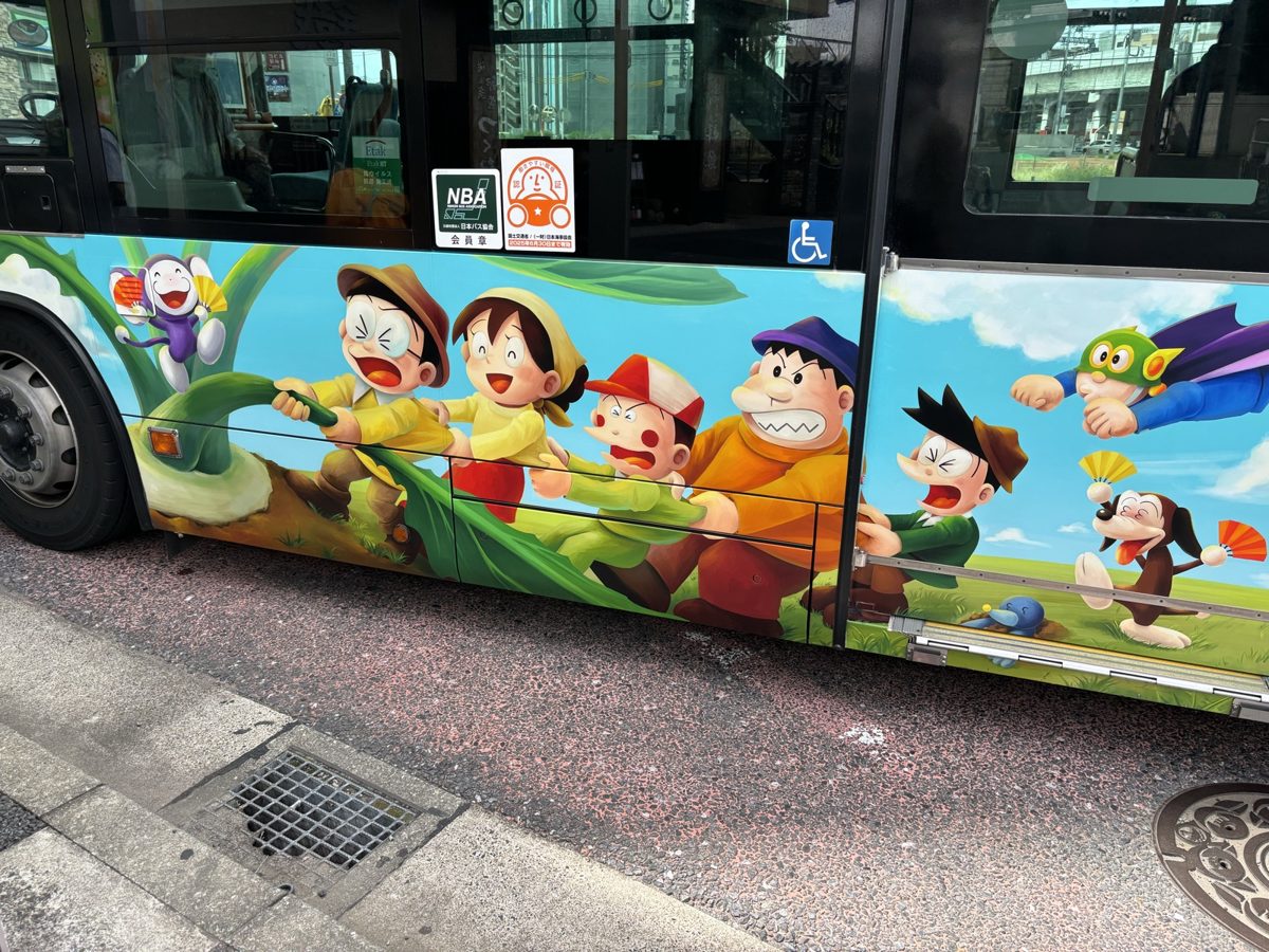登戸駅からミュージアムへ向かう直行バス|ドラえもんやパーマンなどキャラクターが描かれたラッピングバスの側面