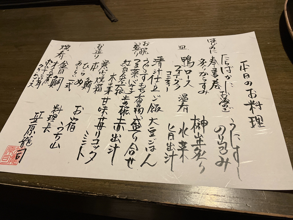 お宿うち山の夕食で出された手書きのお品書き。鴨ロース、フォアグラ、金目鯛などの文字と料理長の朱印が見える