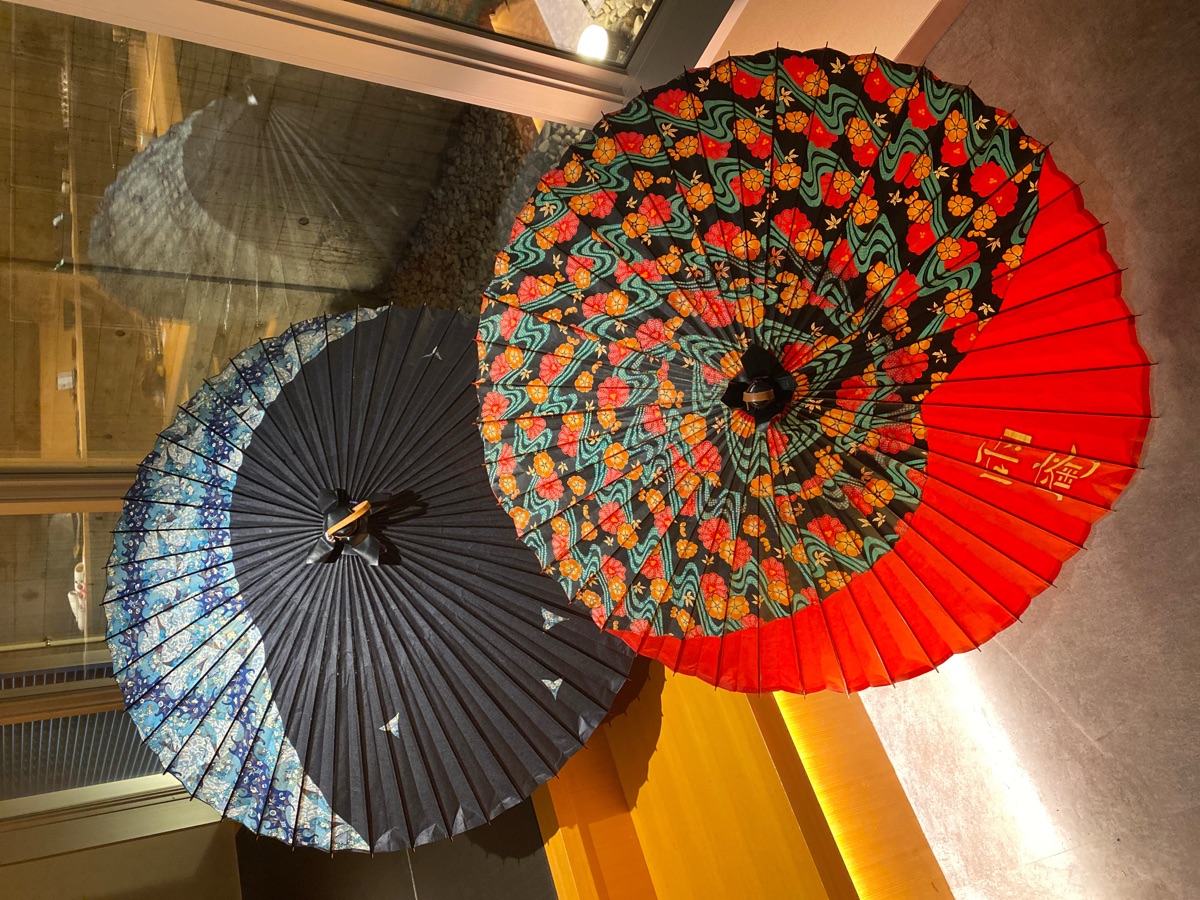 雨庵金沢の館内に飾られた和傘。雨庵の金字が入った赤い和傘と藍色の和傘