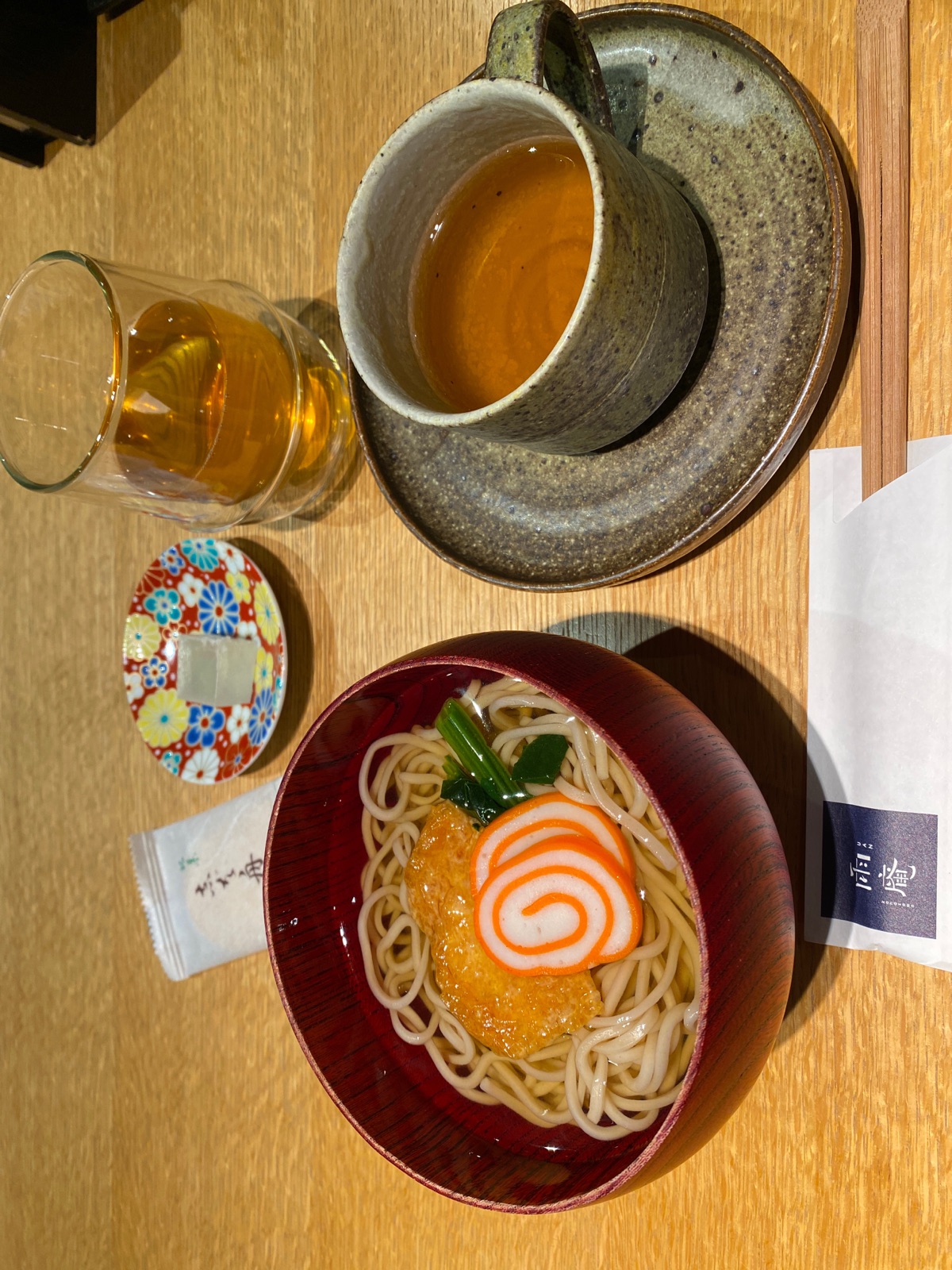 雨庵金沢の無料の夜鳴きそば。赤巻かまぼこののったお蕎麦と金沢棒茶、九谷焼の小皿の和菓子