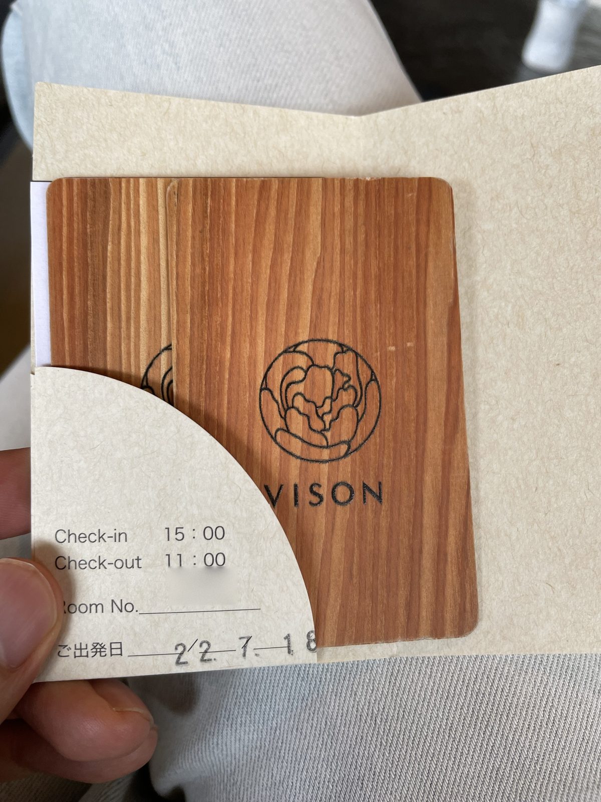 HOTEL VISONの木のカードキーと袋。印字はチェックイン15:00、チェックアウト11:00(2022年7月)