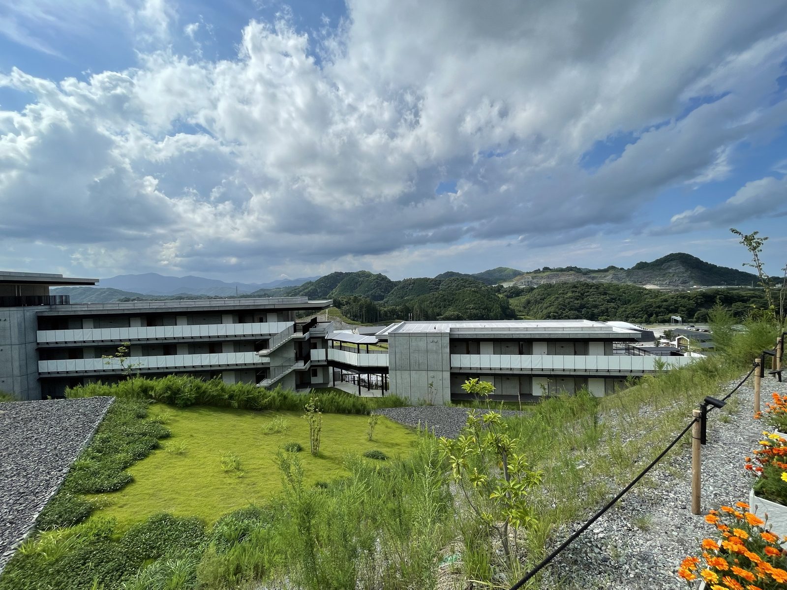 VISONの丘の上の小道から見た建物と山並み（2022年7月）