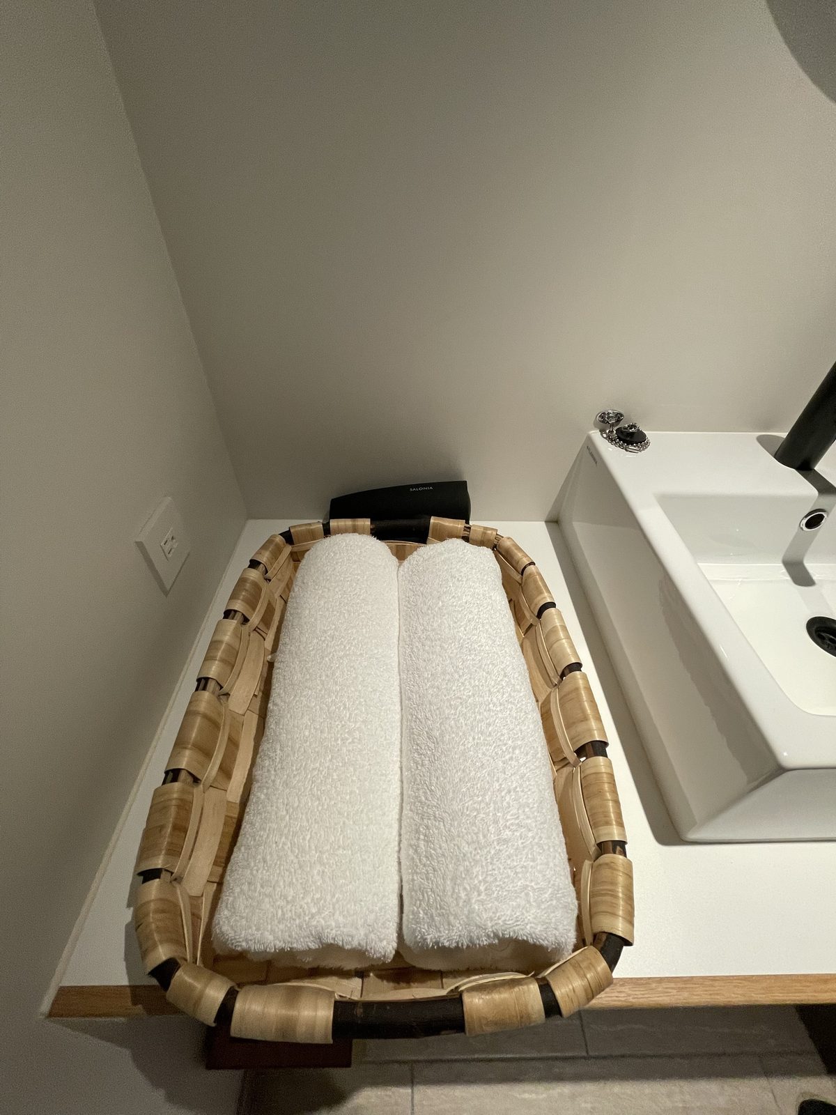 HOTEL VISONの洗面台の横のかごに入った白いタオル(2022年7月)