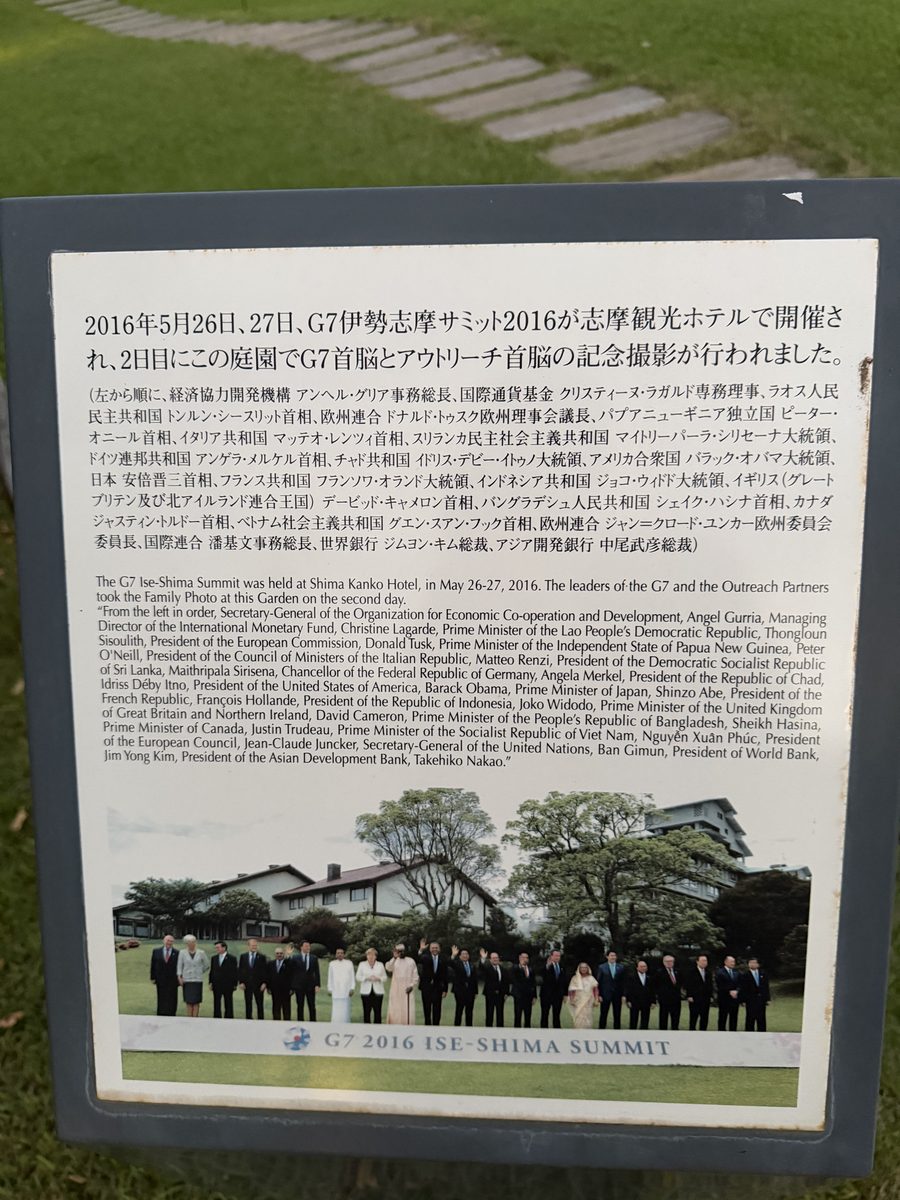 庭園に立つG7首脳とアウトリーチ首脳の記念撮影の説明板